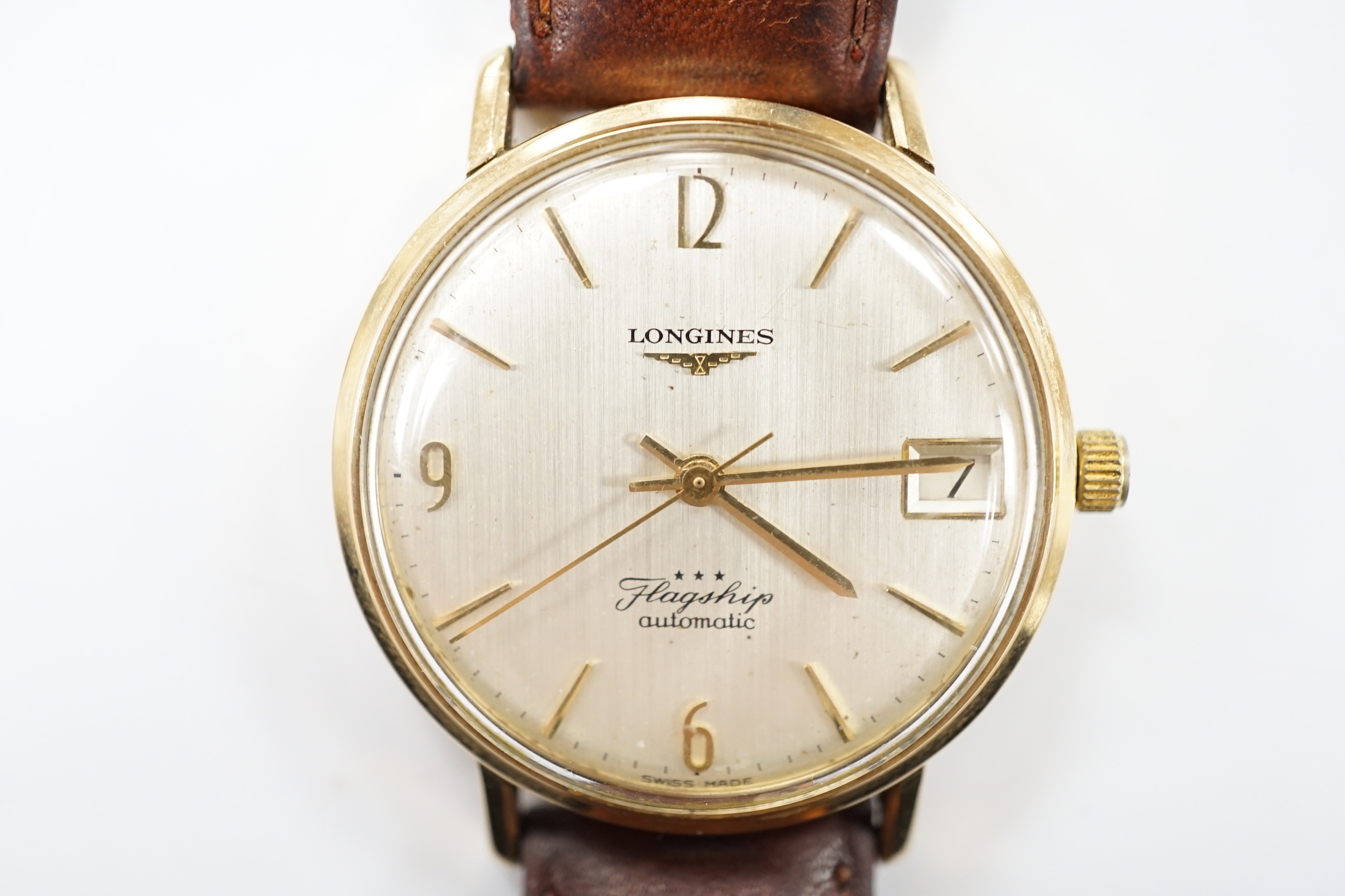 A gentleman's 9ct gold Longines Flagship automatic wrist watch, with baton numerals and date aperture, on associated leather strap.